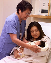Mother and baby with nurse in hospital