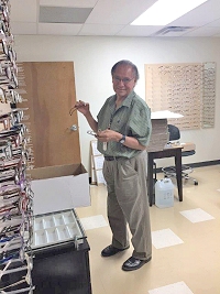Dennis Yazza sets up the eyeglasses gallery in the new building on moving day.