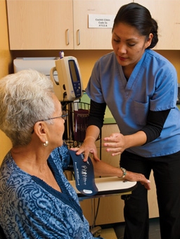Woman nurse with patient while measuring blood pressure