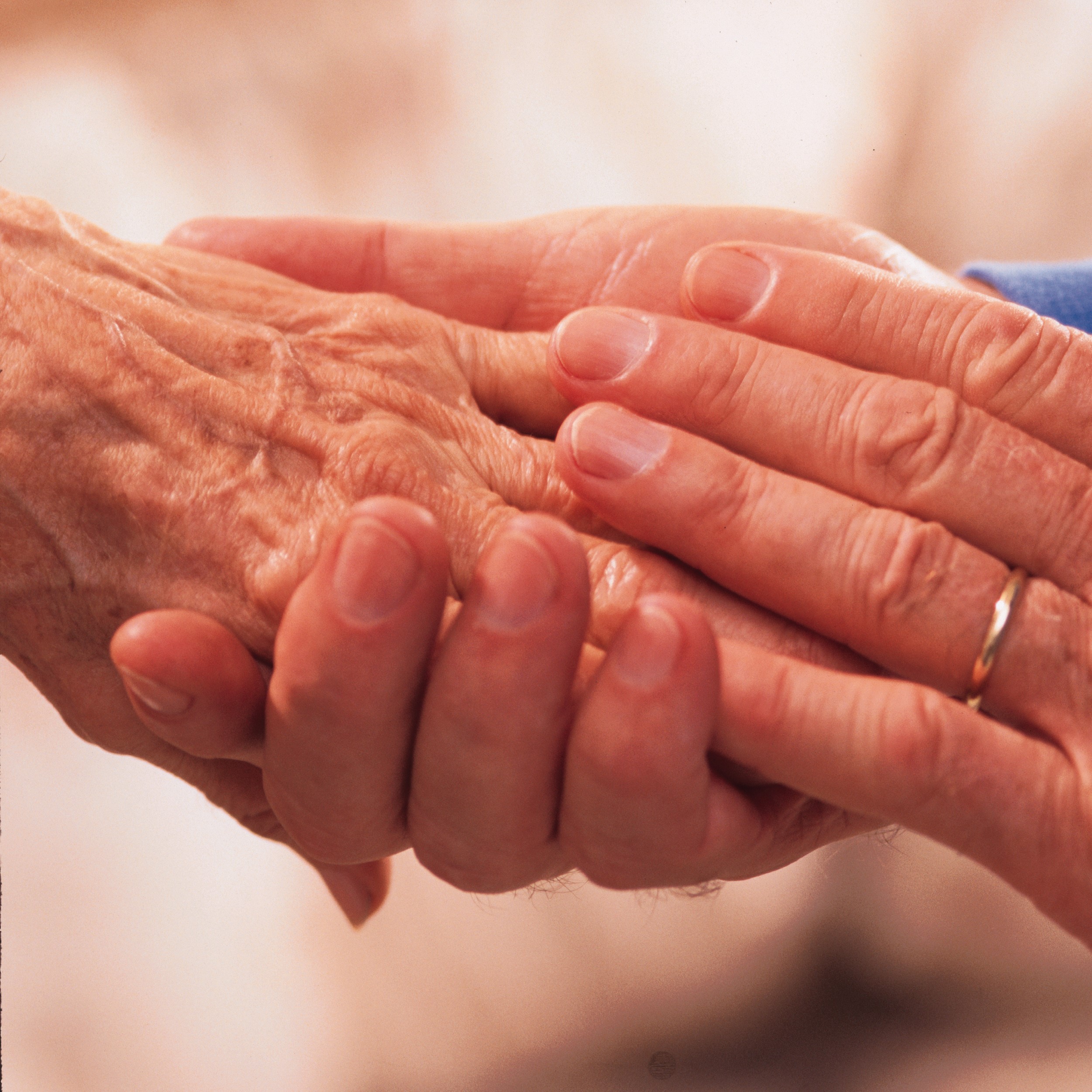 a hand clutching an elder's hand