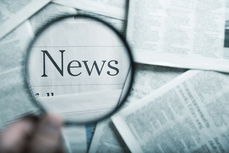 magnifying glass over newspaper.