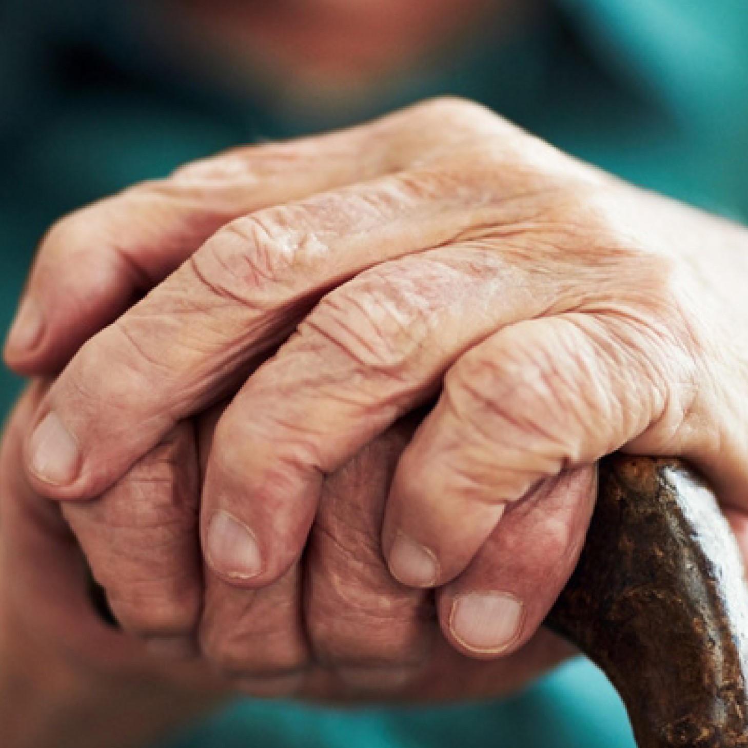 an elders hands resting on a cane