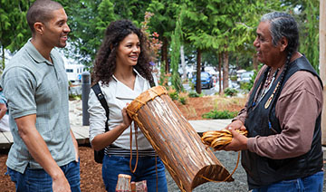 Picture of a native elder discussing native culture with two young adult.