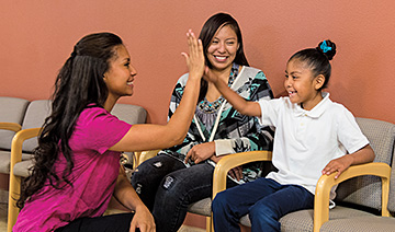 Woman nurse high fiving with girl patient