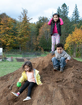 Native youth playing on a dirt hill