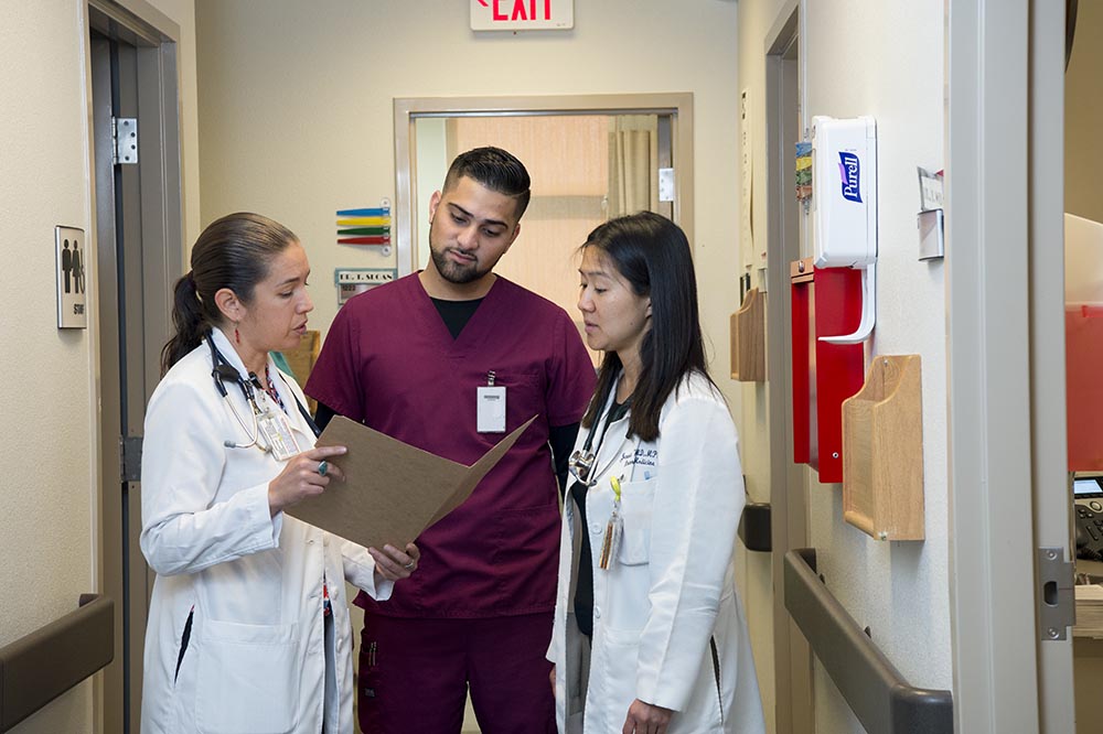 A nurse consults two physicians on a patient case file at a local tribal medical facility