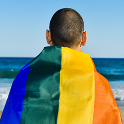 A person wrapped in an LGBTQ flag