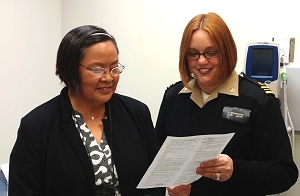 U.S. Public Health Service Lt. Cmdr. Angela Zimmerman, PHN, educates clinic employee Kay Stainbrook on the importance of influenza vaccination for patients of all ages.