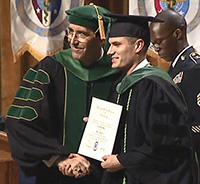 USPHS Lt. Colin Smith receives his Doctor of Medicine diploma during the Uniformed Services University School of Medicine commencement ceremony in Washington, D.C., May 21, 2016.
