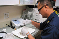 CDR Vince Garcia prepares mosquito specimens for West Nile virus testing.