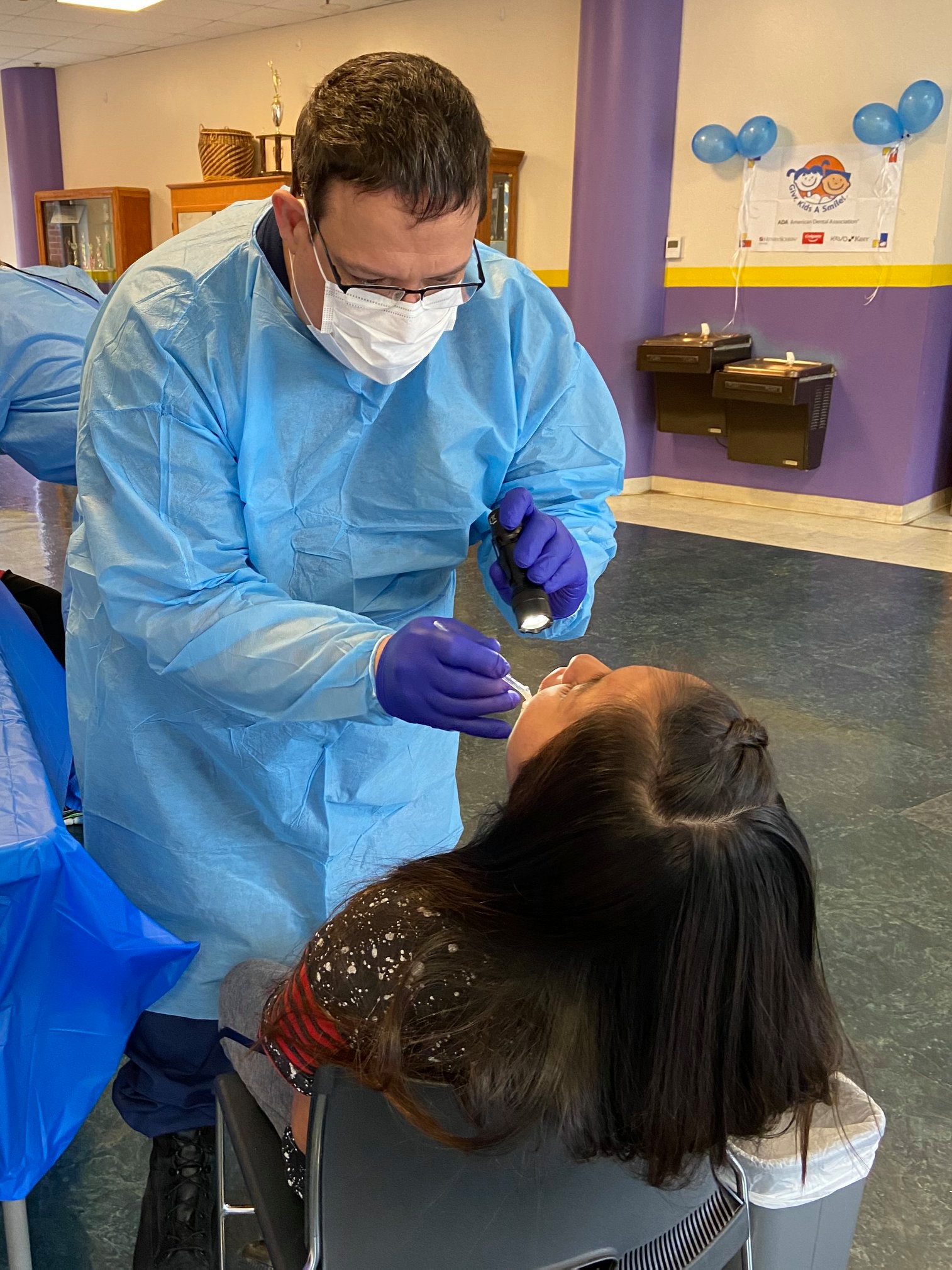 Rear Adm. Ricks providing a dental screening at Choctaw Middle School in Mississippi during a Give Kids A Smile event on February 7, 2020.