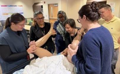 Participants practicing a clinical procedure on a medical training mannequin.