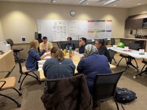 Participants seated around a table during a group training session.
