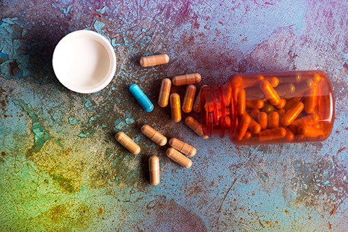 Pills spilled on a multi-colored distressed surface