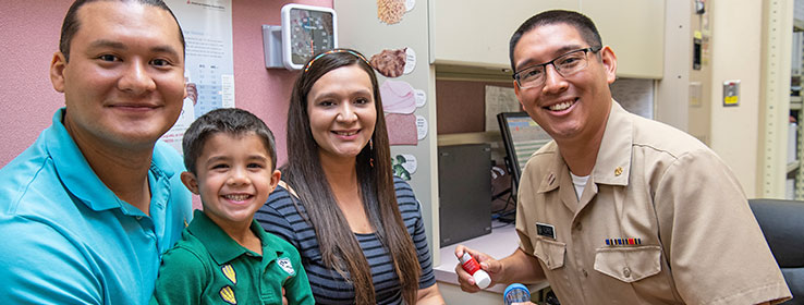 A child patient with his parent and a male staff