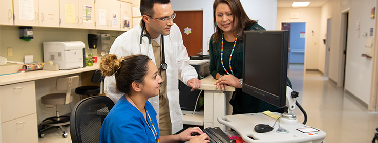 A male and two female medical staff working.