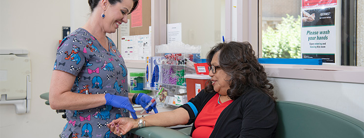 A female medical staff giving shot to a female patient.
