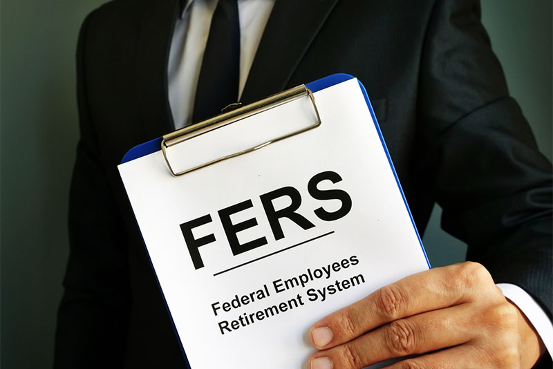 A man holding a clipboard with a page that say FERS Federal Employees' Retirement System.