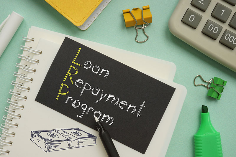 a notebook with a paper on it that says Loan Repayment Program