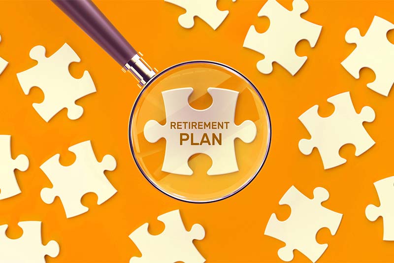 Puzzle pieces scattered around and a magnifying glass hovering over one that says Retirement Plan.