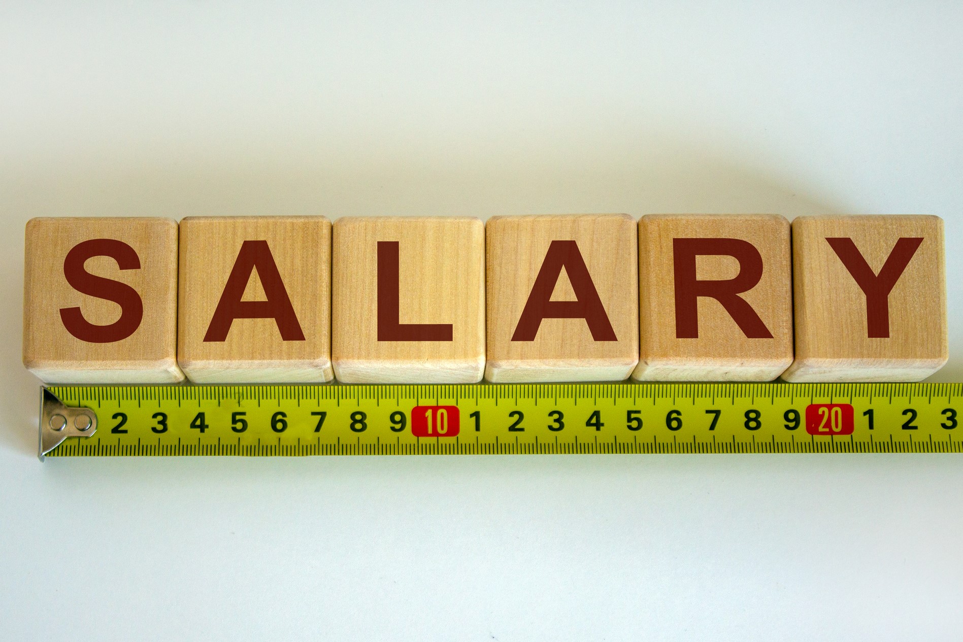 The word Salary spelled out on blocks with a measuring tape under it.