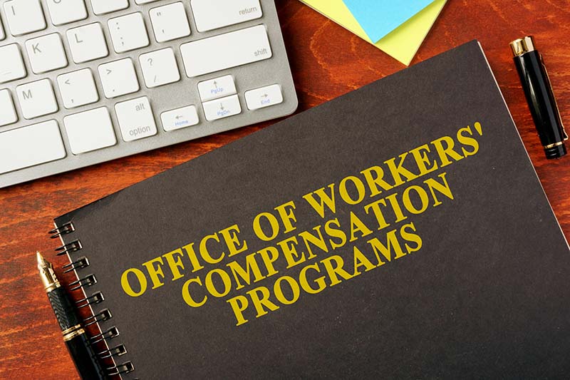 A notebook on a table with the title Office of Workers' Compensation Programs on it.