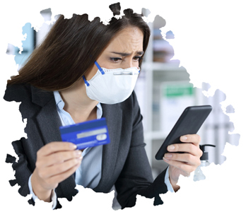 Woman wearing facemask, holding smartphone and credit card, looking upset.