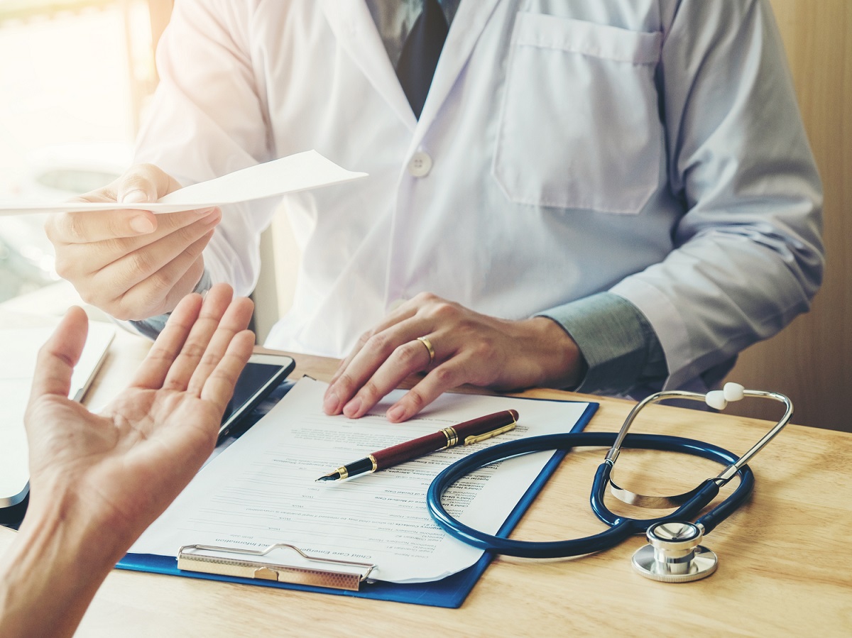 Doctor handing patient a paper prescription