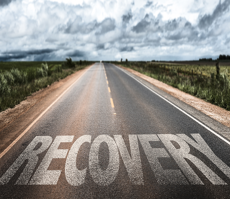 two lane road with recovery stenciled on the pavement