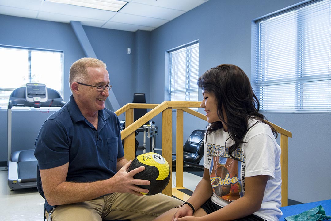 girl doing physical rehabilitation with Physical Therapist