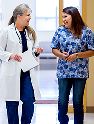 Woman doctor and woman nurse conversing.