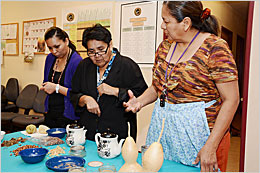 Three women looking at traditional food.