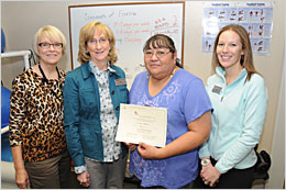 DIHFS staff members posing with a successful Fork n' Road Weight Management Program client.