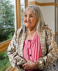 An elderly woman looking out the window