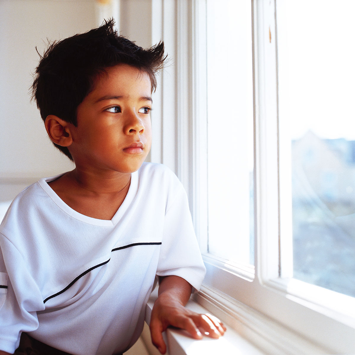 A little boy looking out the window